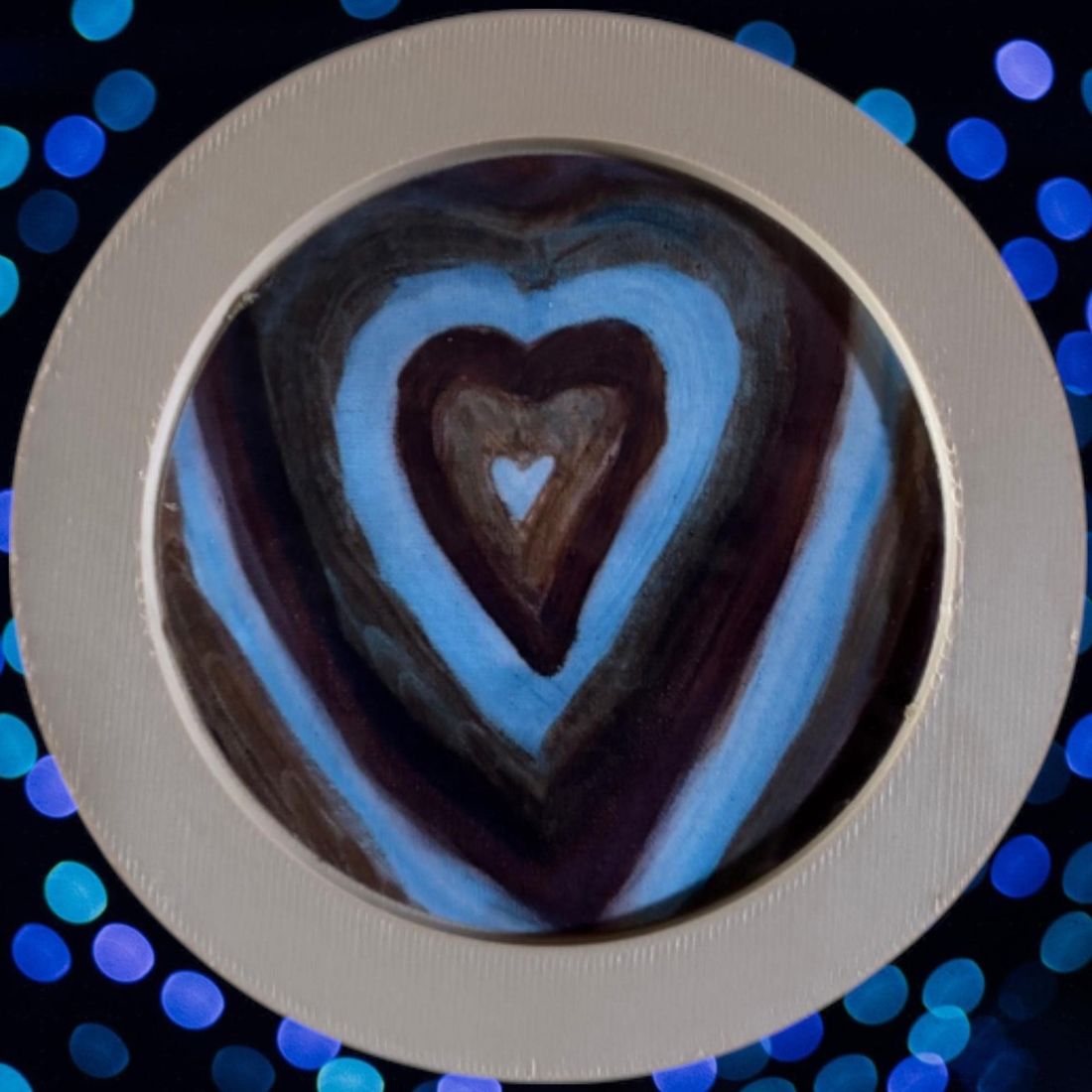 A round coaster printed with a painting of hearts